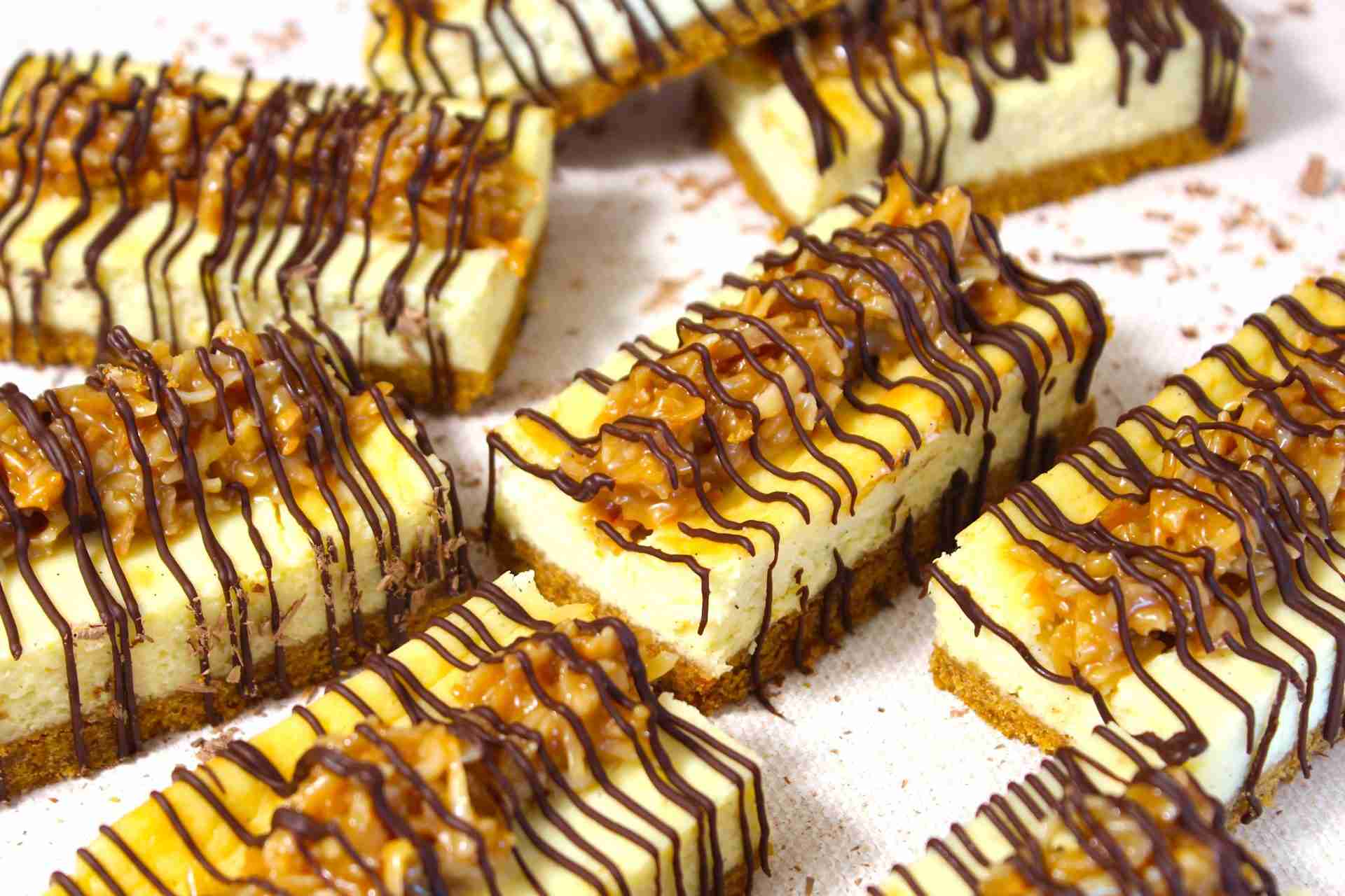 Delectable caramel drizzled cheesecake bars with a chocolate swirl, ready to satisfy any sweet tooth craving.